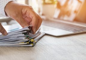 Accountant hand use calculate financial report, counting on calculator for checking financials analyzing documents paperwork with laptop computer in modern office, Accounting planning budget concept